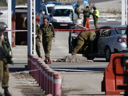 Soldados israel&iacute;es junto al cuerpo de un palestino que dispar&oacute; el pasado domingo en el paso militar Beit El, cerca de Ramala.