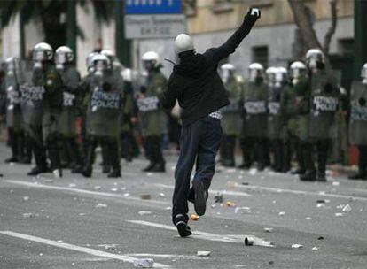 Un manifestante se enfrenta a la policía arrojando piedras en la primera manifestación del año, el pasado viernes en Atenas