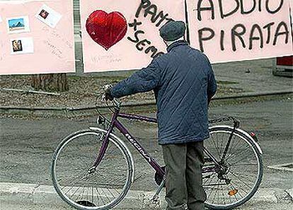 Un viejo ciclista se detiene ante carteles de recuerdo a Pantani en su ciudad, Cesenatico.