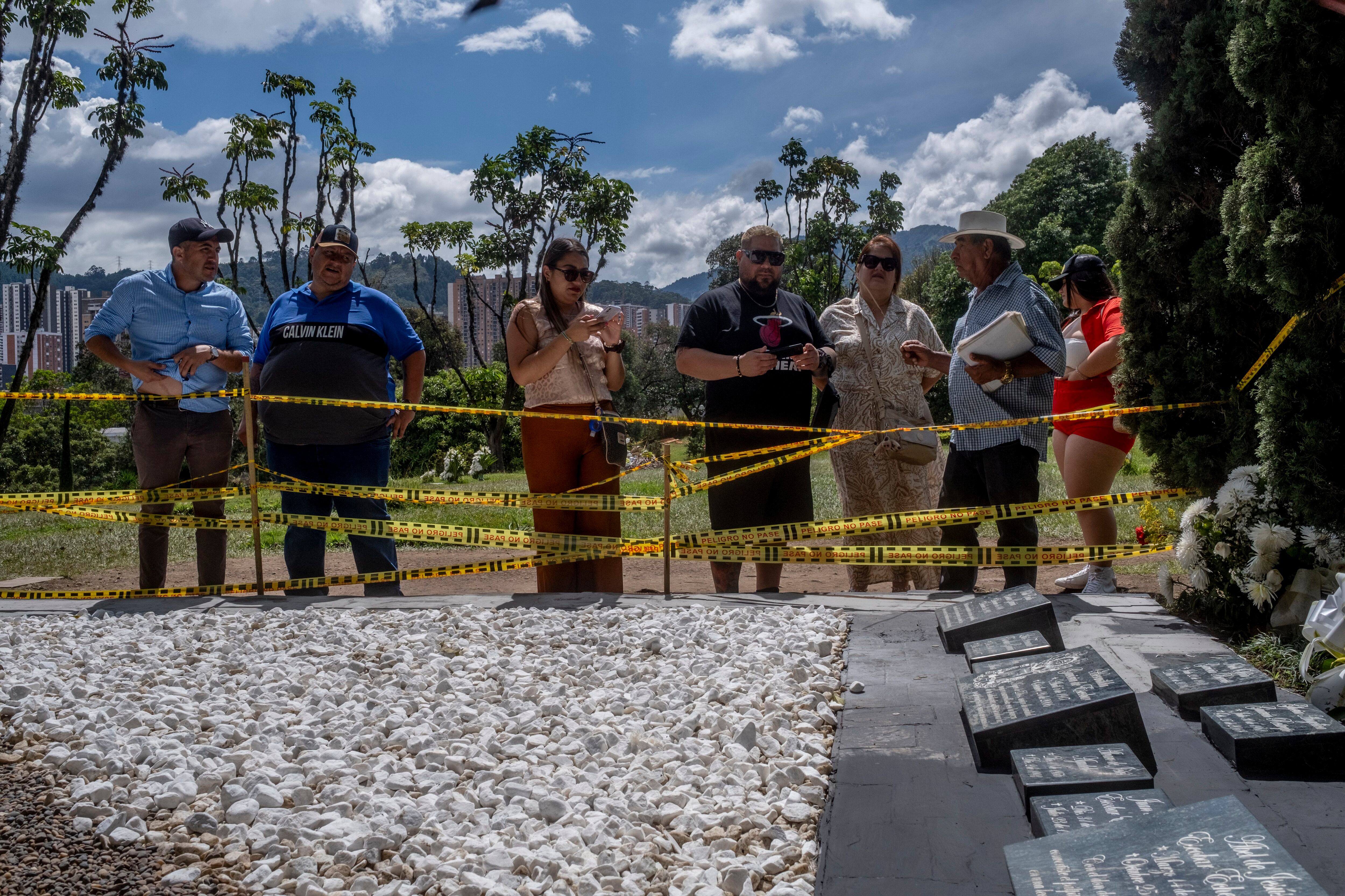 Varios turistas se acercan a la tumba de Pablo Escobar para hacer fotos, en Medellín, el martes 21 de noviembre de 2023.