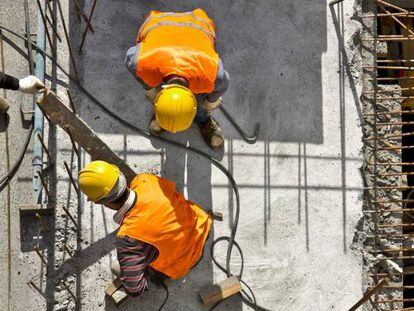 Un grupo de empleados de la construcción trabaja en las obras de un edificio.