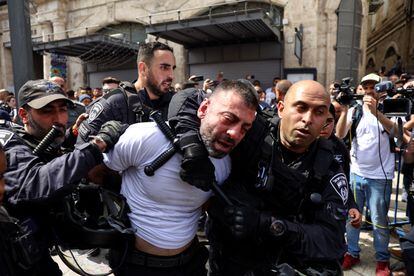 Policías israelíes detienen a un asistente al funeral de la reportera de Al Jazeera. Akleh, de 51 años, murió el miércoles por el impacto de una bala en la cabeza mientras cubría una incursión militar israelí en la ciudad de Yenín, en la Cisjordania ocupada.

