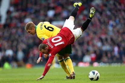 Rooney cae ante el jugador del Norwich Michael Turner.