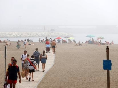 Cientos de bañistas disfrutan de la playa de Huelín de Málaga, durante el festivo del Primero de Mayo, donde el Taró, un tipo de niebla o bruma muy densa y persistente., fue el principal protagonista.
