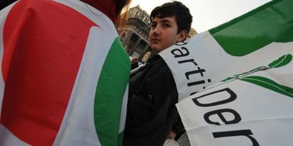 Un joven italiano lleva una bandera del Partido Democr&aacute;tico en un mit&iacute;n de la formaci&oacute;n. 