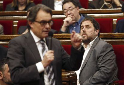 El presidente de ERC, Oriol Junqueras (i), escucha al presidente de la Generalitat, Artur Mas (de espaldas), durante la sesión de control al gobierno catalán.