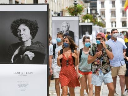Paseantes, ayer al mediodía, por la calle Larios, en Málaga, donde se ha instalado una exposición de fotografías dedicada al festival.
