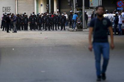 Un manifestante se aleja de un cord&oacute;n policial en el centro de El Cairo