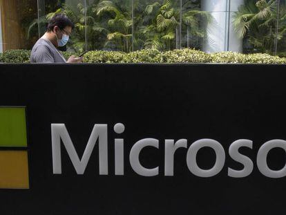 Un hombre pasa junto a logo de Microsoft en las oficinas de la compañía en Pekín. 