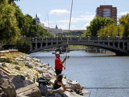 Personas pescando en el r&iacute;o Manzanares a la altura del Puente de la Reina Victoria, en Madrid.