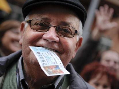 Un jubilado muestra su décimo ganador del primer premio en la Lotería de Navidad.