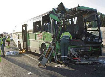 La Guardia Civil de Tráfico inspecciona el autocar de la empresa Larrea accidentado ayer en la autovía de A Coruña (A-6). A la izquierda, el cadáver tapado de María Re.