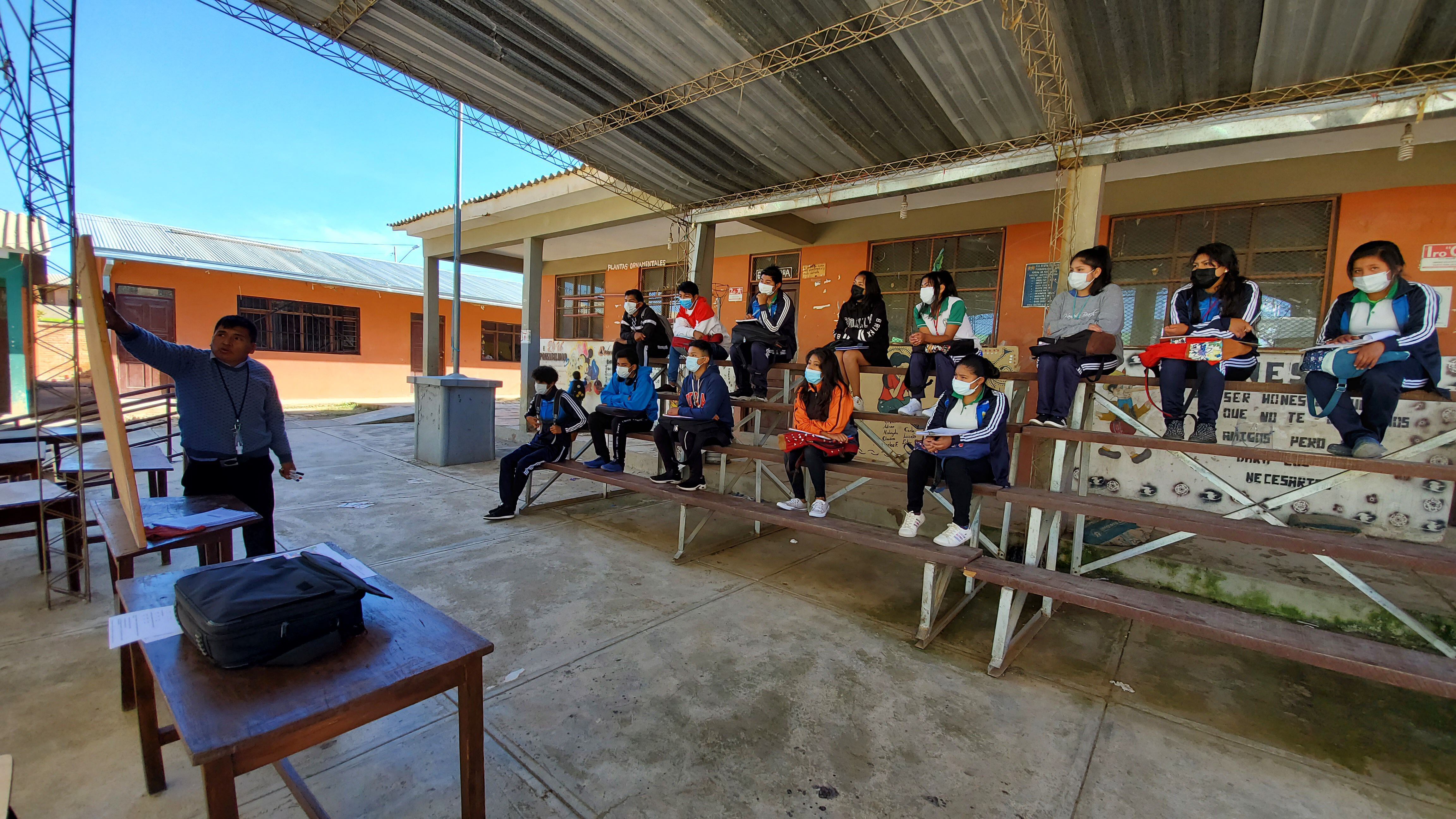 Estudiantes de secundaria del colegio Nueva Veracruz, en Cochabamba, Bolivia, asisten a una clase en el patio debido a que su aula aún no se encuentra habilitada.