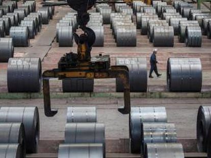 Un trabajador camina junto a rollos de acero en una fábrica de hierro y acero de Changshou (Chongqing, China).