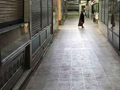 Una mujer camina por el mercado municipal de Bami, en el barrio de Ventas, que el Ayuntamiento prevé vender.