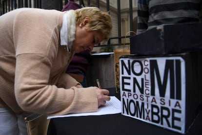 Una mujer completa la petición de apostasía frente a la Conferencia Episcopal Argentina.