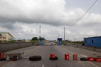 Cajas y neumáticos bloquean una de las autopistas que conectan Abiyán con el norte de país, en un puesto de control de las fuerzas de Ouattara.