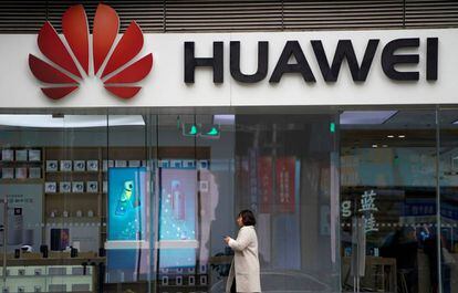 Una mujer pasa caminando por delante de un logo de Huawei el pasado diciembre en un centro comercial de Shangái (China).