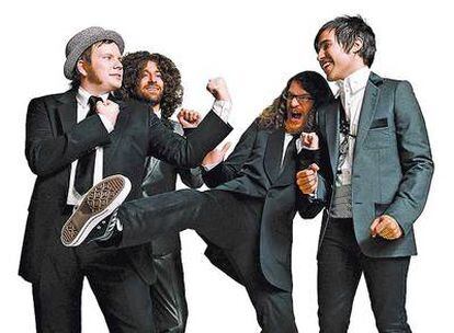 Fall Out Boy con traje y zapatillas, que dan un aire desenfadado, a lo Emilio Aragón. El primero por la derecha es Pete Wentz.