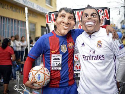 Dos hombres disfrazados de Messi y de Ronaldo. 