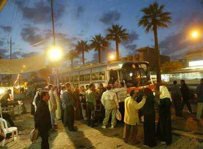 Refugiados iraquíes esperan en la estación de Bagdad para subir a un autobús con destino a Siria.