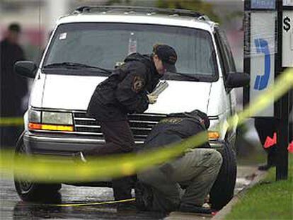 Dos policías examinan la furgoneta blanca requisada por las fuerzas de seguridad ayer en Richmond.
