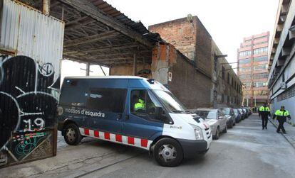 Un furg&oacute;n de los Mossos sale de la nave desalojada ayer.