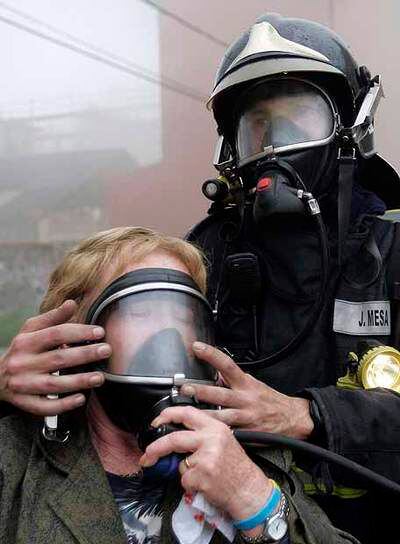 Un bombero ayuda a una mujer que tuvo que ser evacuada.