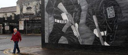 Un hombre camina junto a un mural con paramilitares pintados en Belfast, el lunes. 