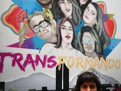 Natalia Aventín, madre de Patrick, junto a un cartel sobre transexualidad del centro LGTBI de Medellín (Colombia).
