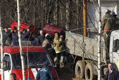 Miembros de los equipos de rescate rusos trasladan ataúdes en el lugar del accidente.