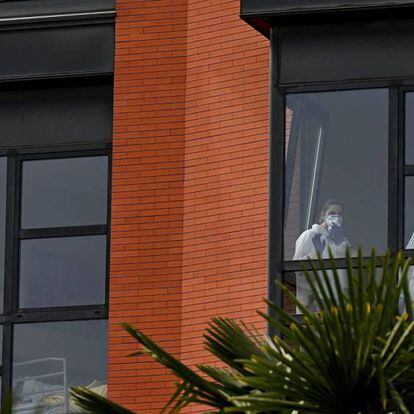 Varios trabajadores miran por la ventana desde el interior de la residencia de ancianos Monte Hermoso, este miércoles, en Madrid.