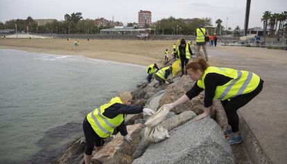 Voluntaris recollint escombraries a la platja, aquest dissabte.