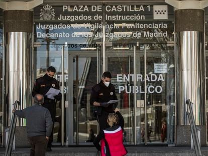 Dos guardias de seguridad de los juzgados de Plaza Castilla, en Madrid, controlan, el pasado viernes, que solo accedan personas con cita.