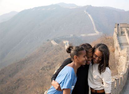 Michelle Obama abraza a sus hijas Sasha y Malia en la Gran Muralla China en marzo de 2014.