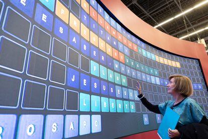 Lídia Jorge writes on the screen where visitors leave phrases in the European Community pavilion.