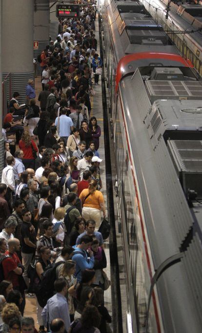 Imagen de pasajeros en un andén de la estación madrileña de Atocha a la espera de subir en el Cercanías.