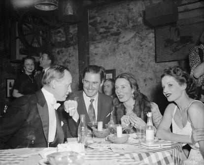 Errol Flynn, en el centro, durante una cena con amigos en un club de Washington en 1939.