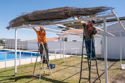 Francisco García y José Naharro, vecinos de Miravete, trabajaban el martes en la reapertura de la piscina del pueblo tras el incendio en Monfragüe, en Cáceres.
