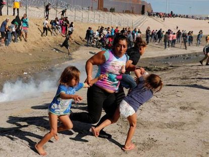 Una familia de migrantes escapa del lanzamiento de gases lacrimógenos en Tijuana. En vídeo, la Policía de EEUU emplea gas lacrimógeno contra 500 migrantes de la caravana que trata de cruzar la frontera en Tijuana.