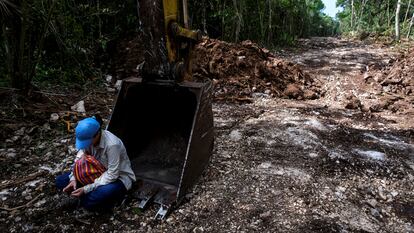 Una activista se sienta sobre maquinaria para evitar que continúe trabajando en la construcción del tramo 5 del "Tren Maya", en Akumal, Estado de Quintana Roo (México), el 2 de agosto.