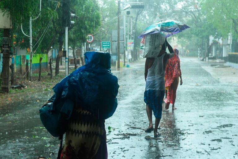 Residentes de la ciudad india de Diga, en Bengala Occidental, se dirigen hacia un refugio ante la llegada del super ciclón Amphan, este miércoles.