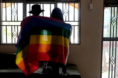 Una pareja gay de Uganda se cubre con una bandera LGTBI el 25 de marzo de 2023
