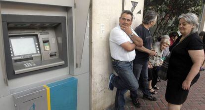 Ciudadanos hacen cola ante una sucursal del Banco Nacional de Grecia