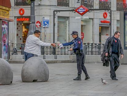 Un policía municipal de Madrid pone una multa a un viandante por no respetar la cuarentena en Madrid.