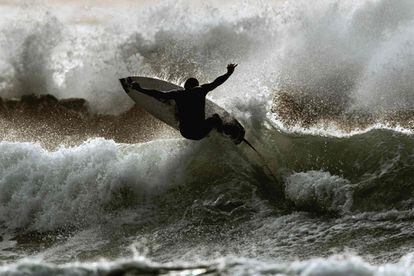 Un surfista monta una ola en la ciudad costera israelí de Netanya.