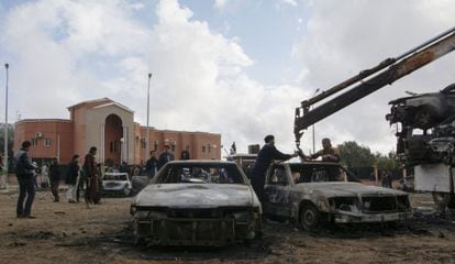 Una gr&uacute;a retira los coches calcinados por el atentado del domingo en Shahat, en el este de Libia