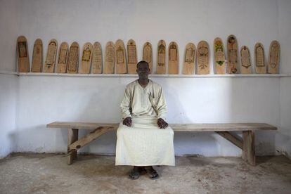 Aboubakar Yaro, jefe de conservación de la Biblioteca de Djenne (Malí), delante de algunos manuscritos sobre madera del Corán.