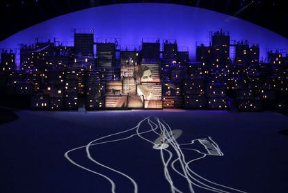  La modelo brasileña Gisele Bündchen camina por el escenario mientras  una imagen del compositor brasileño Tom Jobim se proyecta sobre unos edificios.