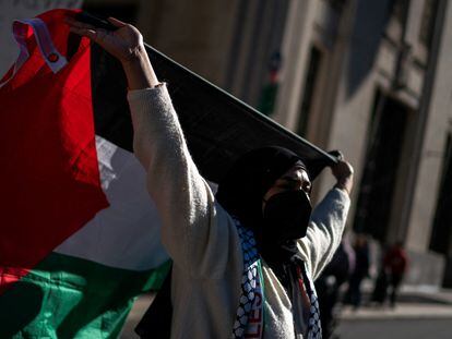 Una mujer eleva una bandera de Palestina en una manifestación en apoyo a los gazatíes, en Nueva York.